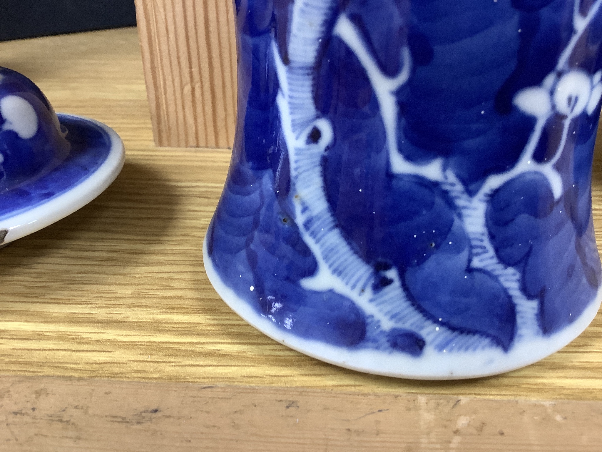 A pair of early 20th century Chinese blue and white prunus vases and covers, height 30cm